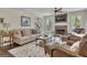 Cozy living room featuring a stone fireplace with TV, comfortable seating, and natural light from large windows at 1105 Astoria Ln, Peachtree City, GA 30269