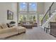 Cozy living room with natural light, comfortable seating, and a staircase with an iron railing at 1105 Astoria Ln, Peachtree City, GA 30269