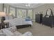 Bright main bedroom with bay windows, ceiling fan, and a comfortable sitting area at 1105 Astoria Ln, Peachtree City, GA 30269