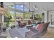 Relaxing covered patio with wicker furniture, stone fireplace, ceiling fan, and serene views of the landscaped backyard at 1105 Astoria Ln, Peachtree City, GA 30269