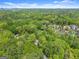 Scenic aerial view of property surrounded by a lush forest and other homes at 3985 Randall Mill Nw Rd, Atlanta, GA 30327