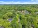 Scenic aerial view of property surrounded by a lush forest and other homes at 3985 Randall Mill Nw Rd, Atlanta, GA 30327