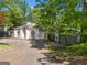 Quaint curb view showcasing a well maintained home with mature trees, arched details, and an attached garage at 3985 Randall Mill Nw Rd, Atlanta, GA 30327