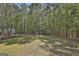 Backyard featuring mature trees and a covered shelter, providing ample space for outdoor activities at 49 Moss Cts, Palmetto, GA 30268