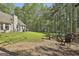 Large backyard features a stone fire pit area and lush lawn, perfect for recreation at 49 Moss Cts, Palmetto, GA 30268