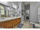 Bathroom featuring double sink vanity, large mirror, and tiled floors leading to walk-in closet at 49 Moss Cts, Palmetto, GA 30268
