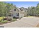 The side exterior of a charming two-story home featuring an attached garage and manicured landscaping at 49 Moss Cts, Palmetto, GA 30268