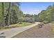 Picturesque two-story home featuring dormer windows, a long driveway and lush greenery at 49 Moss Cts, Palmetto, GA 30268