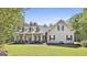 Charming two-story home with a welcoming front porch, manicured lawn, and beautiful landscaping with mature trees at 49 Moss Cts, Palmetto, GA 30268