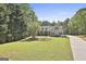 A beautiful 2-story house with dormer windows and blue shutters on a large lot surrounded by mature trees at 49 Moss Cts, Palmetto, GA 30268