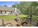 Outdoor seating area with fire pit and view of the backyard lawn at 49 Moss Cts, Palmetto, GA 30268