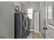 Laundry room featuring front load washer and dryer, storage cabinet, and window for natural light at 49 Moss Cts, Palmetto, GA 30268