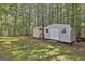 Backyard with green lawn, trees and 2 storage sheds for tools and equipment at 49 Moss Cts, Palmetto, GA 30268