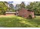 Expansive backyard featuring lush green grass, beautiful landscaping, and a detached brick building at 8289 Lake View Ter, Riverdale, GA 30274