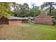 Exterior shot of the brick house's backyard with a stone chimney and plenty of greenery at 8289 Lake View Ter, Riverdale, GA 30274