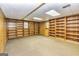 Finished basement area with carpet and wood-paneled walls, featuring custom shelving at 8289 Lake View Ter, Riverdale, GA 30274