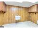 Finished basement area with wood-paneled walls, tile floor, and utility sink at 8289 Lake View Ter, Riverdale, GA 30274