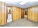 Finished basement featuring wood-paneled walls and access to a bathroom and storage area at 8289 Lake View Ter, Riverdale, GA 30274