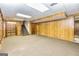 Finished basement featuring wood-paneled walls, carpet floors, and a staircase at 8289 Lake View Ter, Riverdale, GA 30274