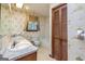 Bathroom featuring double sinks, decorative wallpaper, and a shower-tub combination at 8289 Lake View Ter, Riverdale, GA 30274