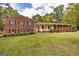 Charming brick home featuring dark shutters, lush green lawn, and mature trees at 8289 Lake View Ter, Riverdale, GA 30274