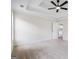 Bright carpeted bedroom features ceiling fan, tray ceiling, and a window at 115 Stewart Hollow Ln, Covington, GA 30016