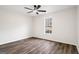 An empty bedroom with a ceiling fan and a window bringing in natural light and hardwood floors at 115 Stewart Hollow Ln, Covington, GA 30016