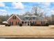 Charming brick home featuring dormer windows, black shutters, and manicured landscaping at 115 Stewart Hollow Ln, Covington, GA 30016