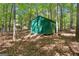 Backyard green shed surrounded by tall trees and leaves at 370 Merrydale Dr, Fayetteville, GA 30215