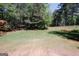 Expansive backyard featuring a lush lawn, mature trees, and a secure fence, providing a private and serene outdoor space at 1417 Se Pickett'S Ct, Conyers, GA 30013