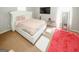 Cozy bedroom with white upholstered bed frame, pink accents, and carpeting at 1417 Se Pickett'S Ct, Conyers, GA 30013