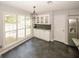 Eat-in kitchen with bright windows, stylish light fixture, and stainless steel refrigerator at 1417 Se Pickett'S Ct, Conyers, GA 30013