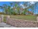 Expansive backyard with lush greenery and scattered trees, ideal for outdoor activities and enjoying nature with a brick fence at 3705 Royer Ln, Hampton, GA 30228