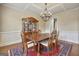 Formal dining room boasts hardwood floors, a coffered ceiling, chandelier and classic furniture set on an ornamental rug at 3705 Royer Ln, Hampton, GA 30228