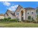 Two-story brick home featuring a meticulously manicured lawn and an arched entryway, creating a welcoming facade at 3705 Royer Ln, Hampton, GA 30228