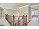 Upstairs hallway with carpet, ornate railing and view into a bedroom with natural light at 3705 Royer Ln, Hampton, GA 30228