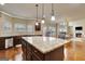 Open concept kitchen features granite island, stainless appliances, hardwood flooring and views of living spaces at 3705 Royer Ln, Hampton, GA 30228