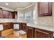 Well-appointed kitchen features granite counters, stainless steel appliances, hardwood floors and dark-stained cabinetry at 3705 Royer Ln, Hampton, GA 30228