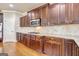 Updated kitchen with custom dark-stained cabinets, granite counters, tile backsplash, and hardwood floors at 3705 Royer Ln, Hampton, GA 30228