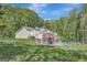 Lush backyard with a fenced pool, deck, and fire pit area, perfect for outdoor living at 140 Horton Creek Trl, Brooks, GA 30205