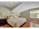 Cozy bedroom with a sloped ceiling, wood floors, and natural light at 140 Horton Creek Trl, Brooks, GA 30205