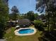 Aerial view of a large backyard with a pool, patio, fire pit, and mature trees creates a private oasis at 308 Summer Pl, Peachtree City, GA 30269