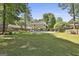 Large backyard with lush green lawn, mature trees, swimming pool, and patio area great for outdoor activities at 308 Summer Pl, Peachtree City, GA 30269
