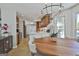 Bright dining area with wood table, modern chandelier, and views of the backyard and pool at 308 Summer Pl, Peachtree City, GA 30269