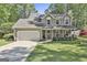 Charming two-story home with a well-manicured lawn, two-car garage, and inviting front porch at 308 Summer Pl, Peachtree City, GA 30269