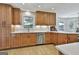 Updated kitchen with stainless steel dishwasher and sink under a window with light wood cabinets at 308 Summer Pl, Peachtree City, GA 30269