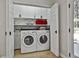 Bright laundry room with white cabinets, a folding table, and a washer/dryer at 308 Summer Pl, Peachtree City, GA 30269