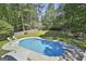 Aerial view of a large backyard pool with a diving board, surrounded by lush greenery and a fence at 308 Summer Pl, Peachtree City, GA 30269