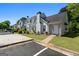 Inviting townhome exterior with manicured landscaping and ample parking on a clear, sunny day at 5882 Trent Walk Dr, Lithonia, GA 30038