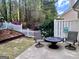 Inviting backyard space with a patio, fire pit, and white picket fence surrounded by mature trees at 403 Rock Creek Dr, Peachtree City, GA 30269